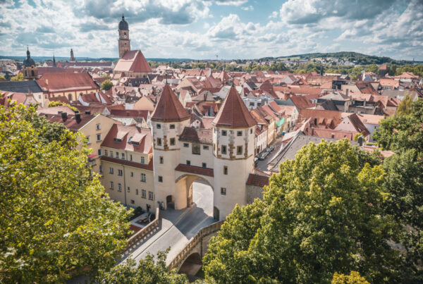 ein großes weißes Gebäude mit roten Dächern und einer Brücke